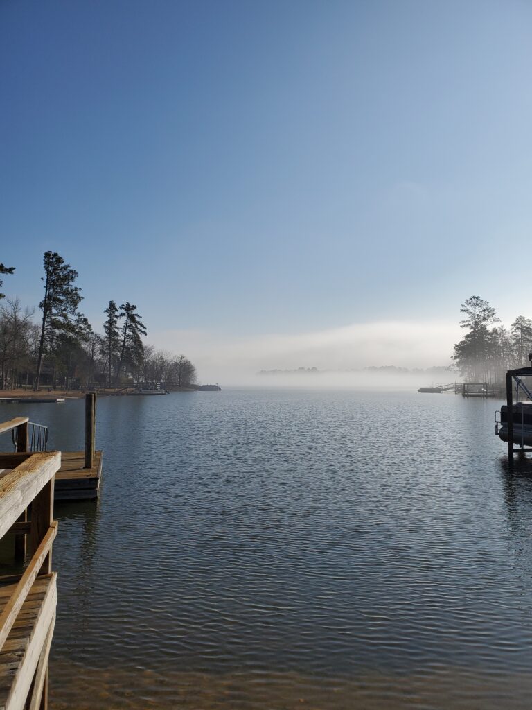 a sunrise over the lake with fog, and a dock